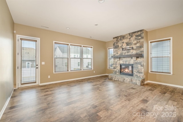 3105 Bonterra Blvd, Indian Trail, NC 28079 - unfurnished living room featuring wood finished floors, a stone fireplace, and baseboards