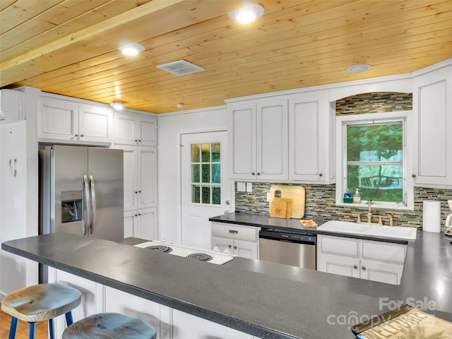 80 Hidden Falls Rd, Maggie Valley, NC 28751 - kitchen with stainless steel appliances, a sink, wooden ceiling, dark countertops, and a breakfast bar
