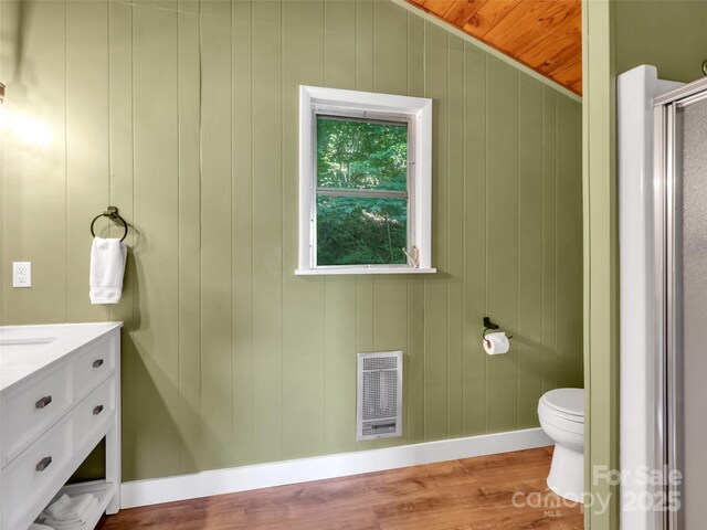 80 Hidden Falls Rd, Maggie Valley, NC 28751 - bathroom featuring heating unit, wood finished floors, toilet, baseboards, and vanity