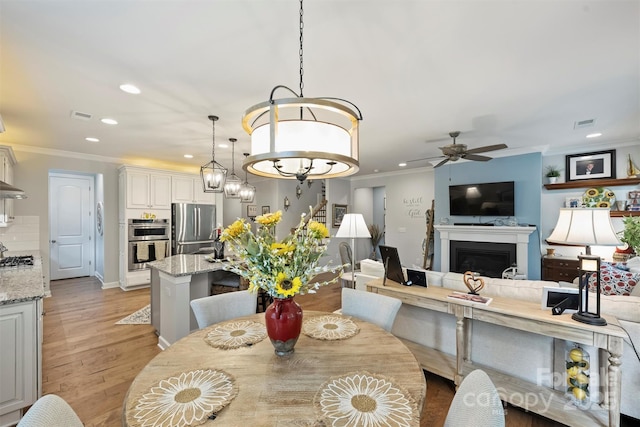 528 Sandbar Pt, Clover, SC 29710 - dining space with ceiling fan, recessed lighting, ornamental molding, a fireplace, and light wood-type flooring