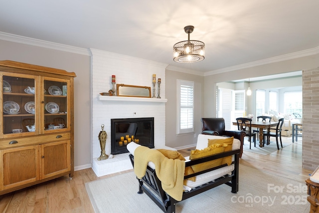 211 Southfork Dr, Belmont, NC 28012 - living room with a chandelier, light wood-style floors, crown molding, a fireplace, and baseboards