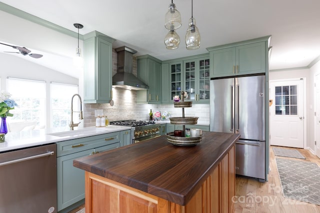 211 Southfork Dr, Belmont, NC 28012 - kitchen featuring stainless steel appliances, a sink, wall chimney range hood, green cabinetry, and decorative backsplash