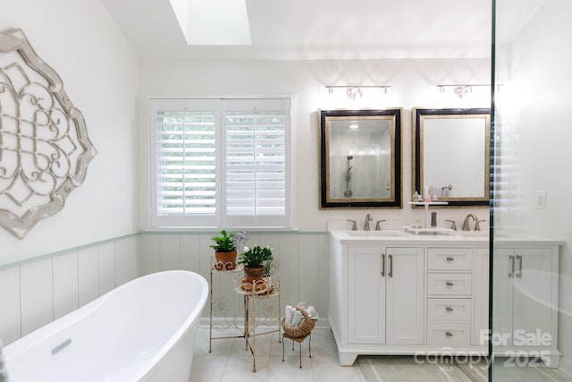 211 Southfork Dr, Belmont, NC 28012 - bathroom with a skylight, double vanity, a freestanding bath, wainscoting, and tile patterned flooring