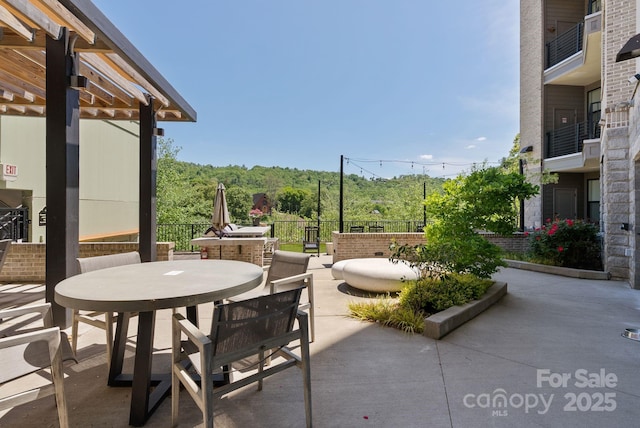 55 S Market St Unit 311, Asheville, NC 28801 - view of patio / terrace featuring outdoor dining area, fence, and a view of trees