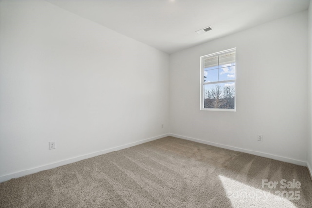carpeted empty room featuring baseboards