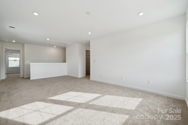 spare room featuring attic access, light carpet, recessed lighting, and baseboards