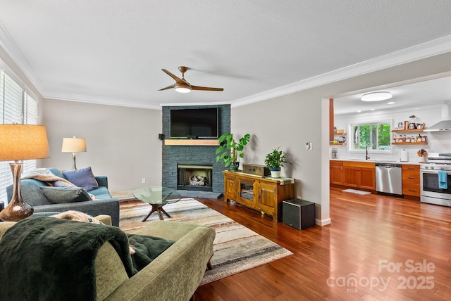 84 Varnadore Dr, Arden, NC 28704 - living room with a stone fireplace, a ceiling fan, dark wood-type flooring, and crown molding