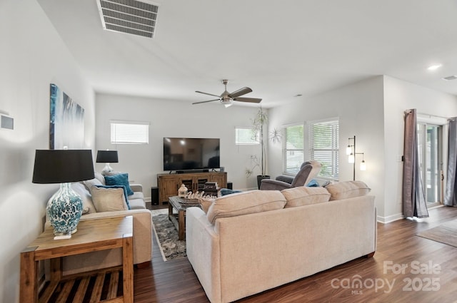 living room with healthy amount of natural light, ceiling fan, dark wood finished floors, and baseboards