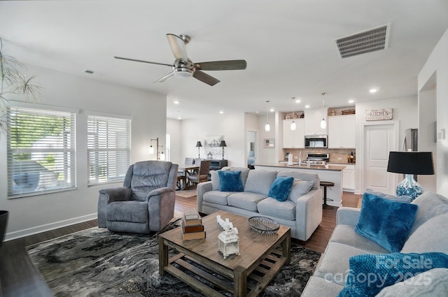 living area with a ceiling fan, dark wood-type flooring, recessed lighting, and baseboards