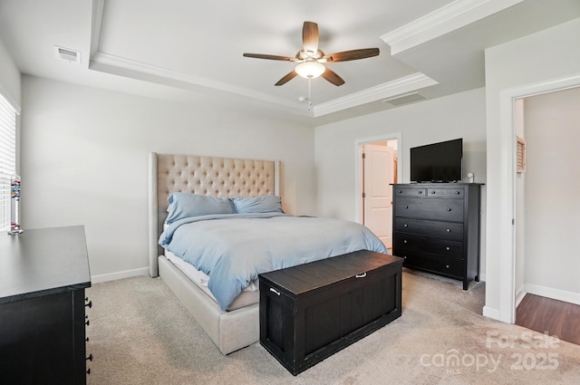 bedroom featuring a tray ceiling, carpet, baseboards, ceiling fan, and ornamental molding