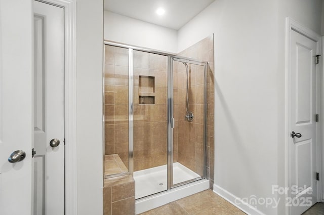 bathroom with a shower stall, tile patterned floors, and baseboards