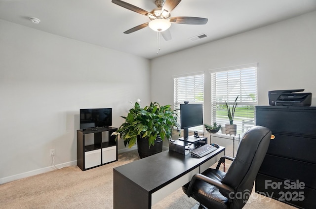 carpeted office with ceiling fan and baseboards