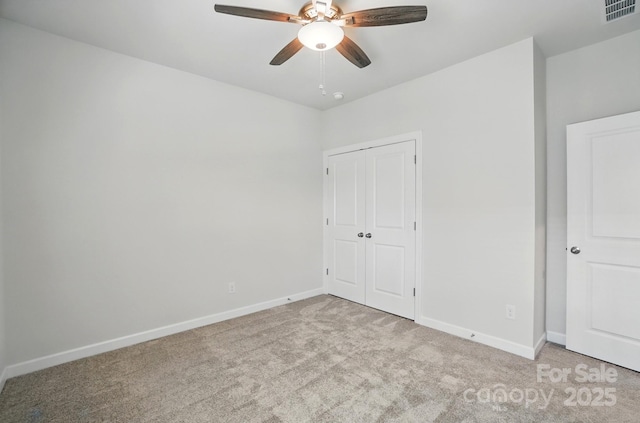 unfurnished bedroom with carpet floors, baseboards, a closet, and ceiling fan