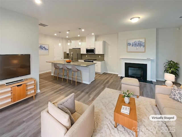 4105 Galloway Park Dr, Charlotte, NC 28262 - living area featuring baseboards, dark wood-style floors, recessed lighting, and a fireplace with flush hearth