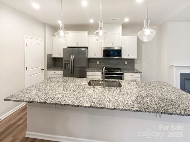 4105 Galloway Park Dr, Charlotte, NC 28262 - kitchen featuring stainless steel appliances, a sink, a large island with sink, decorative backsplash, and white cabinetry