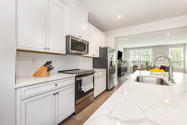 625 Uwharrie River Rd, Charlotte, NC 28211 - kitchen featuring appliances with stainless steel finishes, a sink, open floor plan, white cabinets, and backsplash