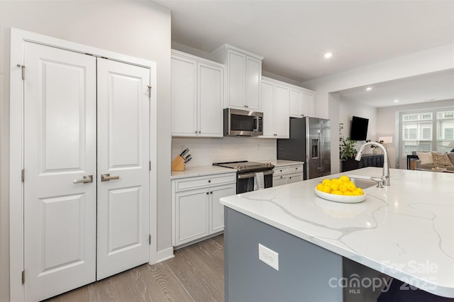 625 Uwharrie River Rd, Charlotte, NC 28211 - kitchen featuring appliances with stainless steel finishes, open floor plan, white cabinetry, light wood-style floors, and tasteful backsplash