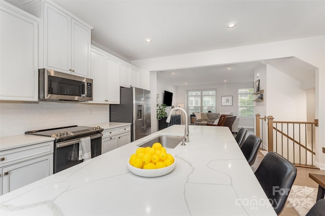 625 Uwharrie River Rd, Charlotte, NC 28211 - kitchen featuring appliances with stainless steel finishes, a sink, open floor plan, white cabinetry, and backsplash