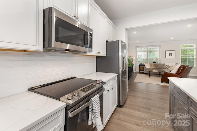 625 Uwharrie River Rd, Charlotte, NC 28211 - kitchen featuring stainless steel appliances, open floor plan, light wood-style flooring, light stone countertops, and recessed lighting
