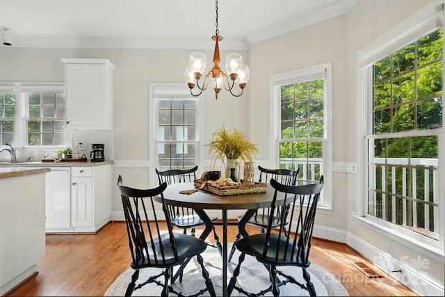 2725 Cotton Planter Ln, Charlotte, NC 28270 - dining room featuring plenty of natural light, a chandelier, light wood finished floors, and ornamental molding