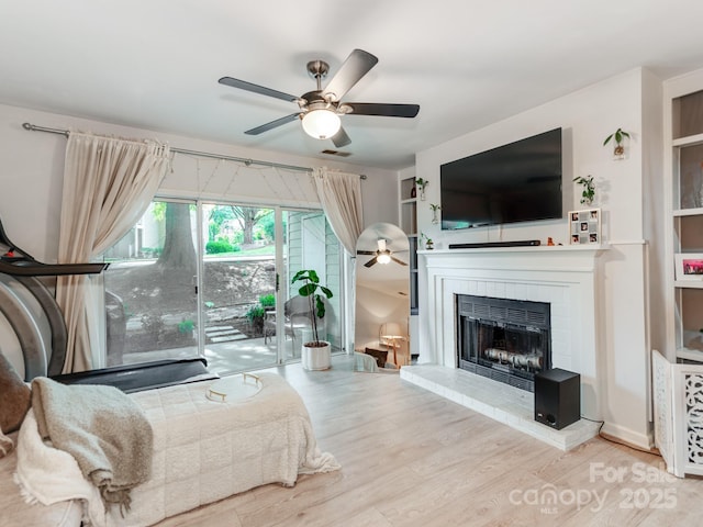 3308 Selwyn Farms Ln Unit 2, Charlotte, NC 28209 - living room featuring ceiling fan, a brick fireplace, and wood finished floors