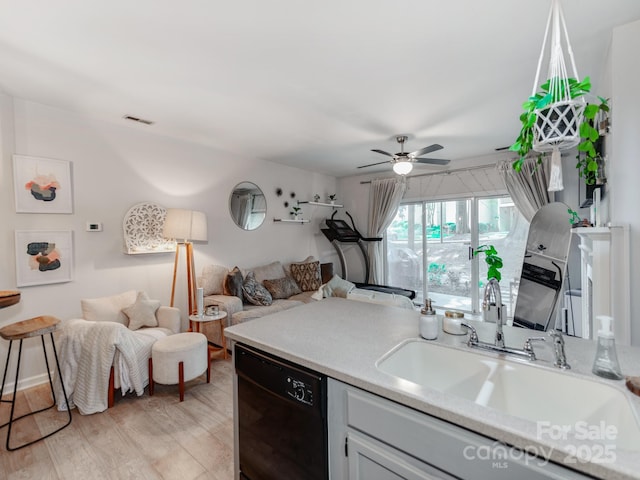 3308 Selwyn Farms Ln Unit 2, Charlotte, NC 28209 - kitchen with black dishwasher, open floor plan, light countertops, ceiling fan, and light wood-type flooring