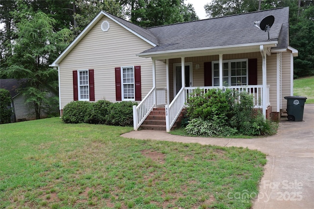 view of front facade with a porch, a front yard, and roof with shingles