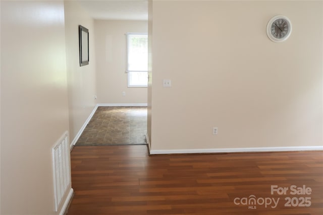 hall with baseboards and wood finished floors