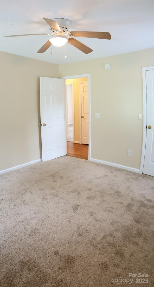 unfurnished bedroom featuring carpet floors, baseboards, and ceiling fan