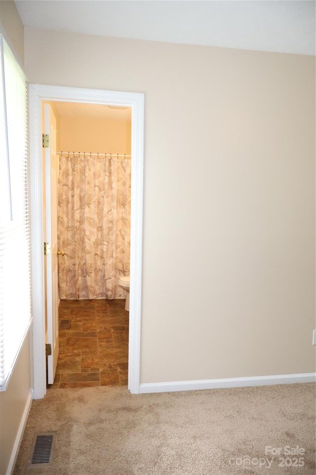 carpeted empty room featuring baseboards