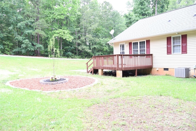 view of green lawn featuring central AC unit and a wooden deck