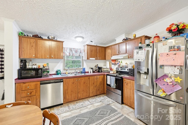 103 Palace Pt, Kings Mountain, NC 28086 - kitchen with stainless steel appliances, under cabinet range hood, crown molding, a sink, and brown cabinetry