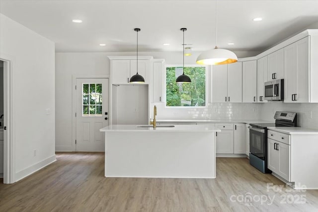 4541 Kings Ct, Hickory, NC 28602 - kitchen featuring appliances with stainless steel finishes, a sink, light wood finished floors, light countertops, and decorative backsplash