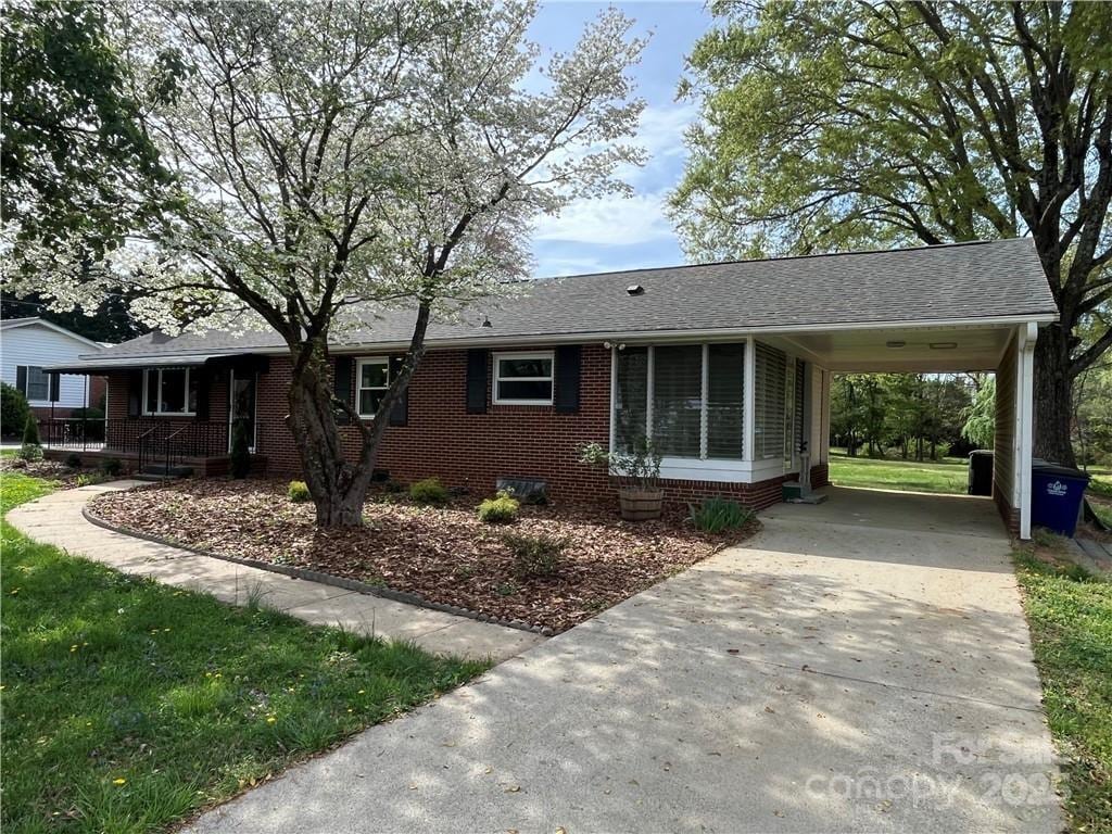 4200 Glenn Hi Rd, Winston Salem, NC 27107 - ranch-style home featuring concrete driveway, an attached carport, brick siding, a shingled roof, and crawl space