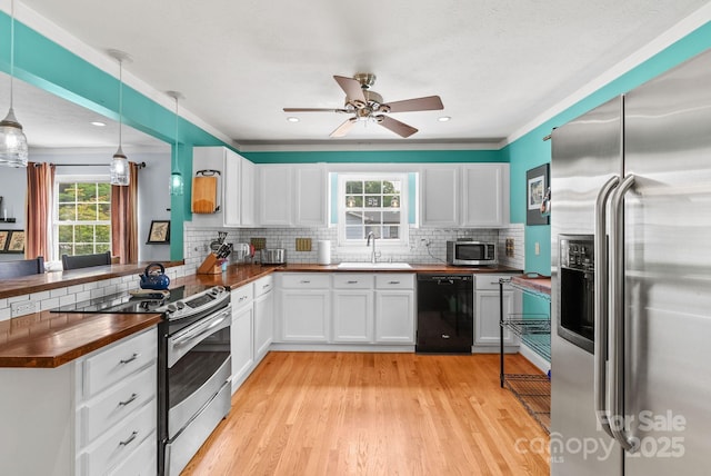 27 Dixon Ter, Candler, NC 28715 - kitchen with appliances with stainless steel finishes, butcher block countertops, plenty of natural light, backsplash, and ornamental molding