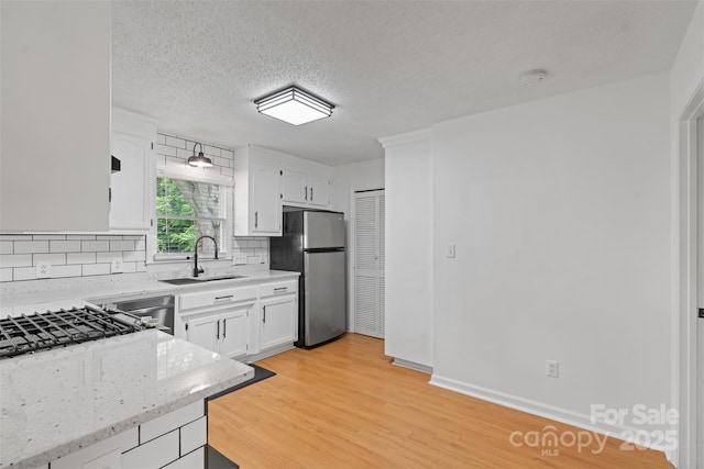 3103 Suggs St, Belmont, NC 28012 - kitchen featuring freestanding refrigerator, a sink, decorative backsplash, light wood-style flooring, and white cabinets