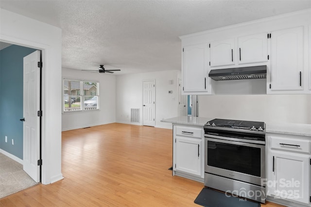 3103 Suggs St, Belmont, NC 28012 - kitchen with stainless steel range with gas cooktop, under cabinet range hood, a ceiling fan, white cabinetry, and light countertops