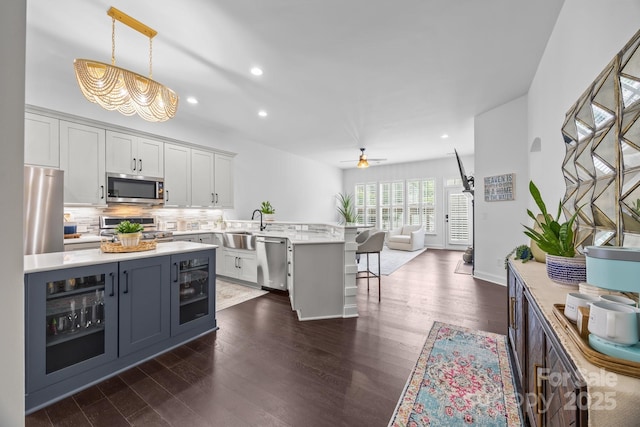 15913 Trenton Place Rd, Huntersville, NC 28078 - kitchen featuring appliances with stainless steel finishes, a sink, a peninsula, open floor plan, and light countertops