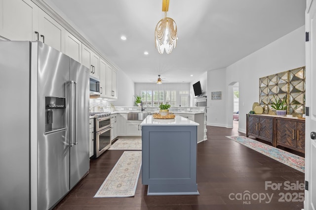15913 Trenton Place Rd, Huntersville, NC 28078 - kitchen featuring high quality appliances, arched walkways, a peninsula, light countertops, and recessed lighting