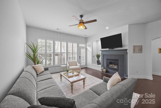 15913 Trenton Place Rd, Huntersville, NC 28078 - living area featuring a ceiling fan, wood finished floors, baseboards, a tile fireplace, and arched walkways