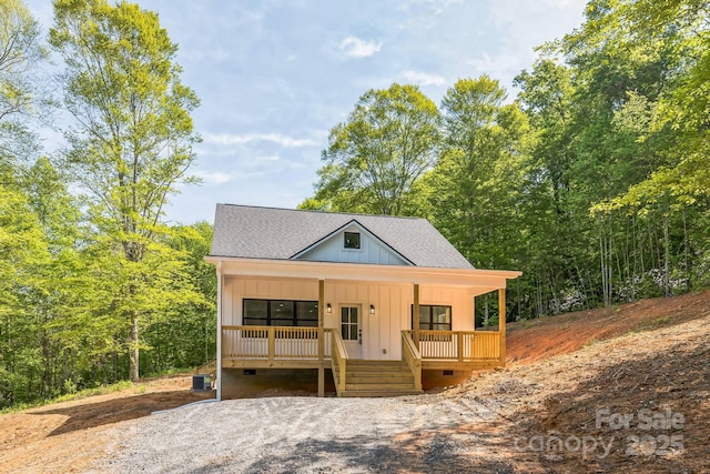 view of front of property featuring a porch, crawl space, board and batten siding, central AC, and roof with shingles