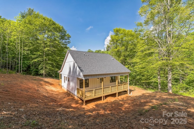 rear view of house with roof with shingles