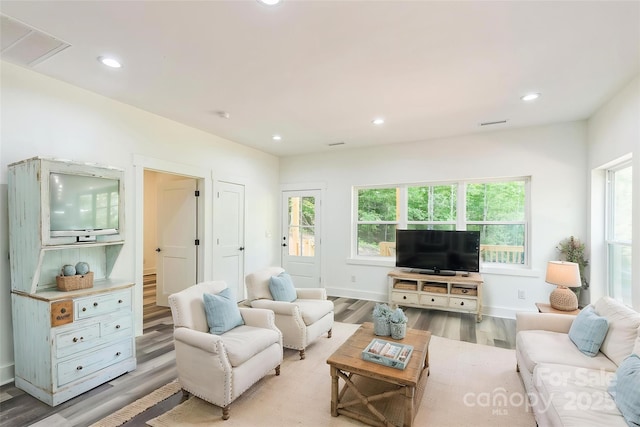 living room featuring light wood-style flooring, recessed lighting, and baseboards