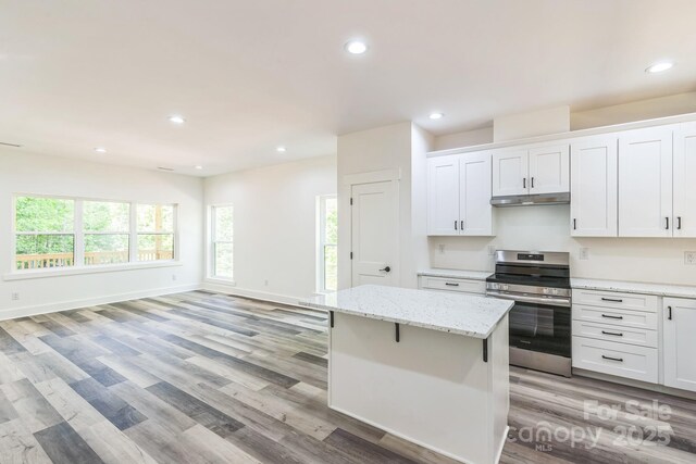 kitchen featuring electric range, under cabinet range hood, white cabinetry, light wood-type flooring, and recessed lighting