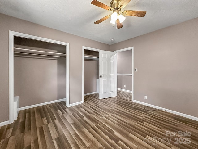 361 Settlemyer Rd, Morganton, NC 28655 - unfurnished bedroom featuring two closets, baseboards, wood finished floors, ceiling fan, and a textured ceiling