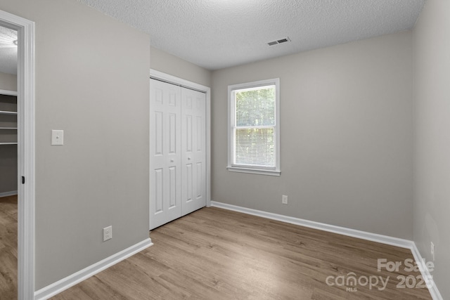 219 Proctor Dr, Salisbury, NC 28147 - unfurnished bedroom with wood finished floors, baseboards, a textured ceiling, and a closet