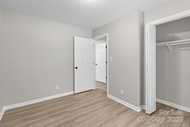 219 Proctor Dr, Salisbury, NC 28147 - unfurnished bedroom featuring light wood finished floors, a closet, baseboards, and a textured ceiling