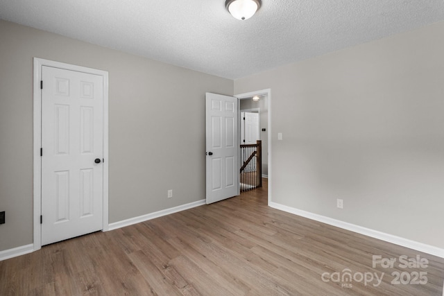 219 Proctor Dr, Salisbury, NC 28147 - unfurnished bedroom featuring wood finished floors, baseboards, and a textured ceiling