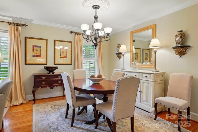 2025 Sagamore Rd, Charlotte, NC 28209 - dining room featuring a chandelier, crown molding, light wood-type flooring, and baseboards
