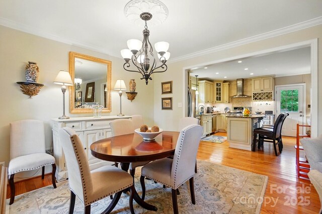2025 Sagamore Rd, Charlotte, NC 28209 - dining space featuring a chandelier, ornamental molding, and light wood-type flooring